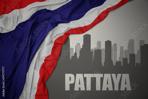 abstract silhouette of the city with text Pattaya near waving national flag of thailand on a gray background.3D illustration
