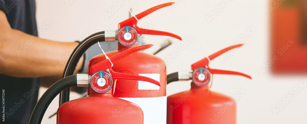 Close up fire extinguisher and firefighter checking pressure gauge level for protection and prevent and safety rescue and use of equipment on fire training concept. Close up fire extinguisher and firefighter checking pressure gauge level for protection and prevent and safety rescue and use of equipment on fire training concept.