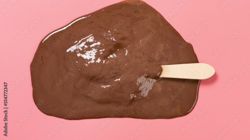 chocolate and coffee flavor popsicle melting timelapse on pink at top view angle chocolate and coffee flavor popsicle melting timelapse on pink at top view angle