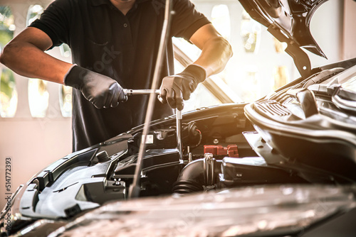 Close-up hand auto mechanic using the wrench to repairing car engine problem. Concepts of check and fix car and maintenance servicing.