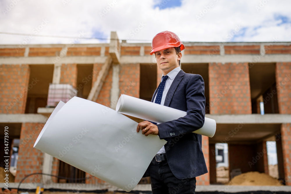 Engineer architect is holding a paper plan of a building at the construction site.. Engineer architect is holding a paper plan of a building at the construction site..