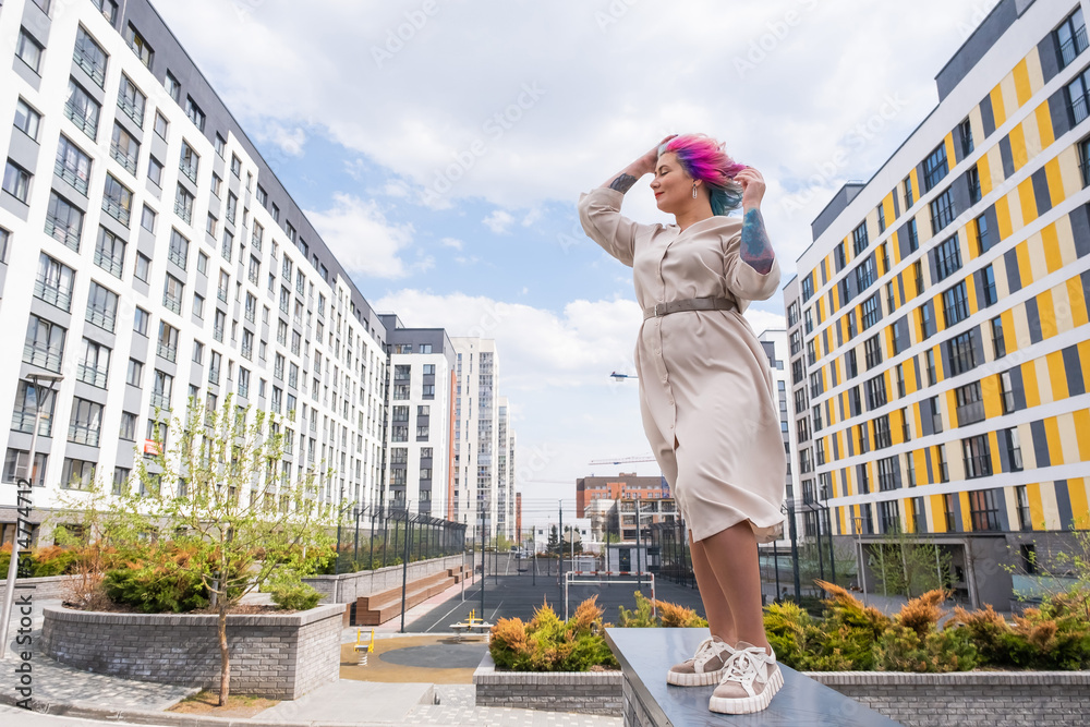 Portrait of a middle-aged woman with multi-colored hair walks on the streets of the city. Portrait of a middle-aged woman with multi-colored hair walks on the streets of the city.