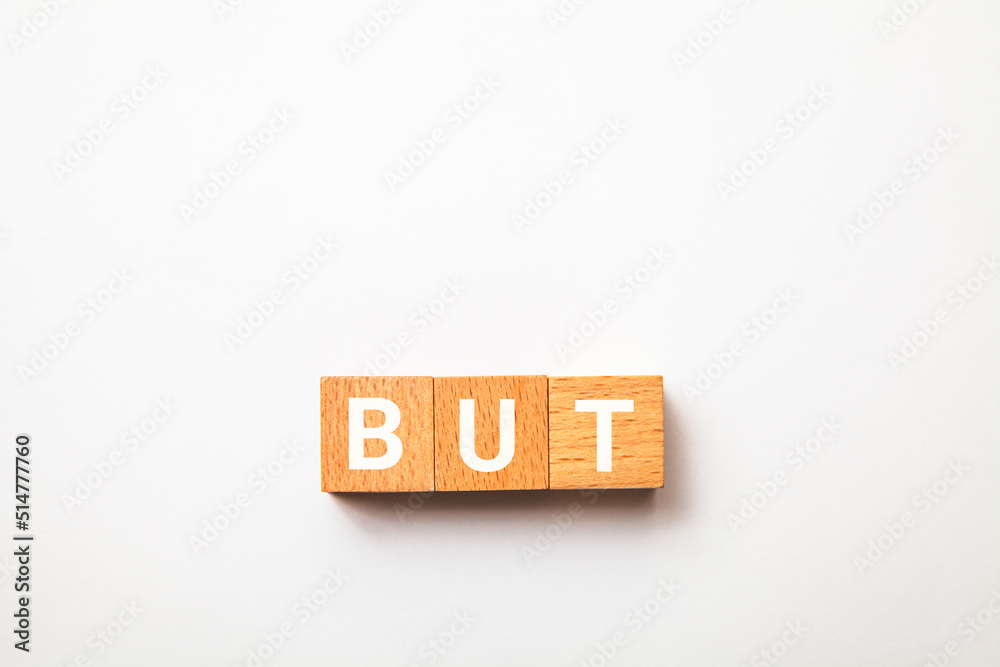 Φωτογραφία BUTの文字。しかし。3つの木製ブロックに書かれている。白い文字。白い背景。