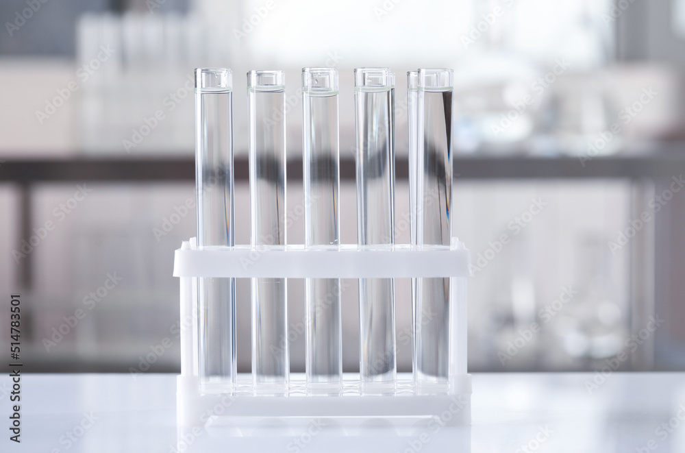 Test tubes with transparent liquid on table in laboratory Test tubes with transparent liquid on table in laboratory