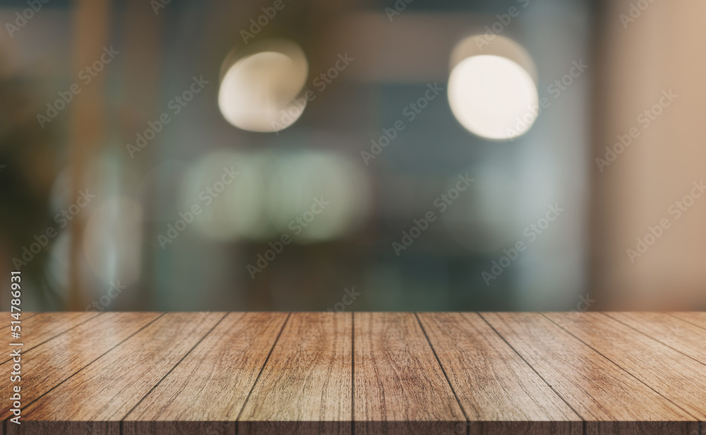 Empty wooden table top with lights bokeh on blur restaurant background.