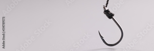 Billede på lærred Closeup of fishing hook on string on gray background