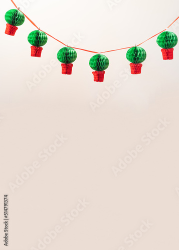 Manjerico paper garland against the beige background with copy space. Traditional Summer festival in June San Juan, Portugal