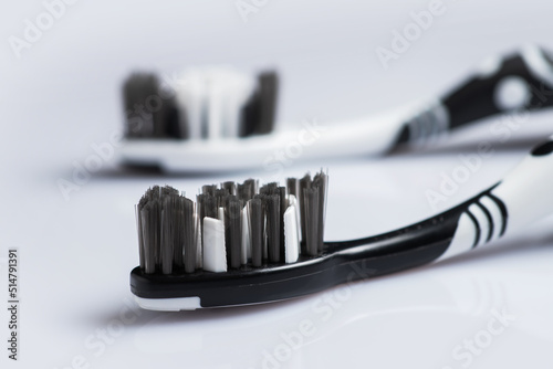 Two toothbrushes black and white color for dental care lies on the table on a white background