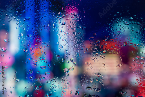 Rain drops and condensation on the window glass against the background of the night city