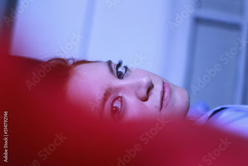 Red-haired woman with blue eyes looks at the camera
