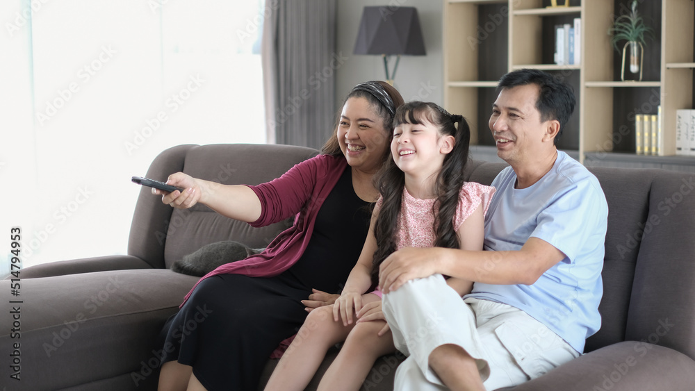Fototapeta premium Happy family watching TV in living room