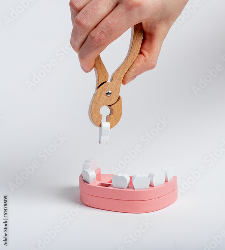 Extracting tooth from jaw model with forceps closeup. High quality photo