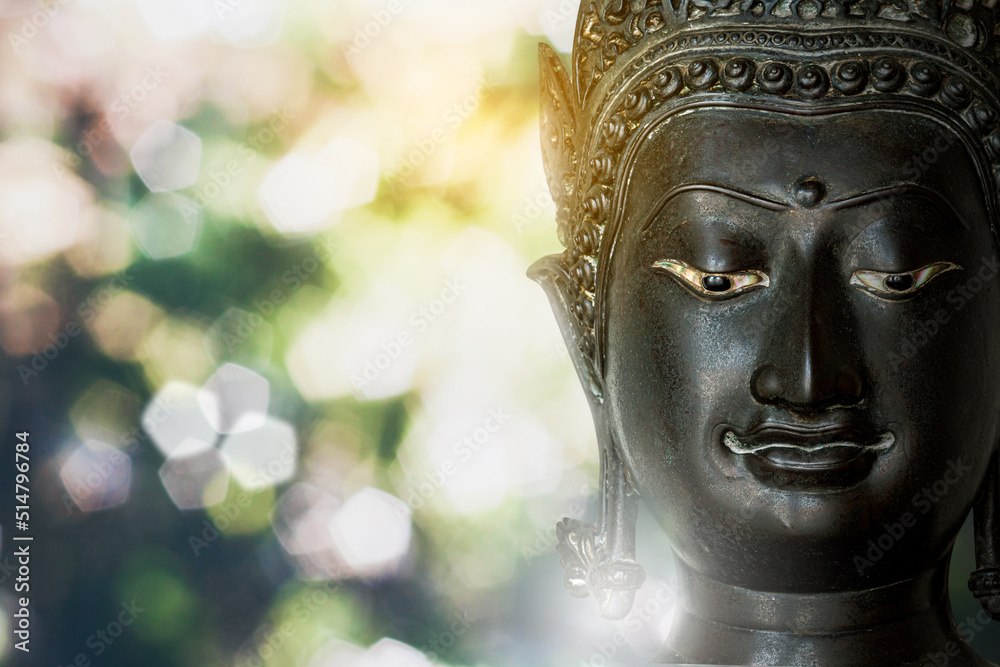 face macro photo Buddha statue made of bronze ancient shape on  white light bokeh