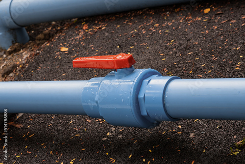 plastic water supply pipes with valve for adjustment close-up photo