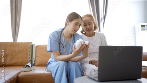 Asian doctor giving an advice and explaining to elder female patient.