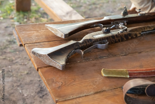 old shotgun with a wooden barrel and an iron stock close-up photo