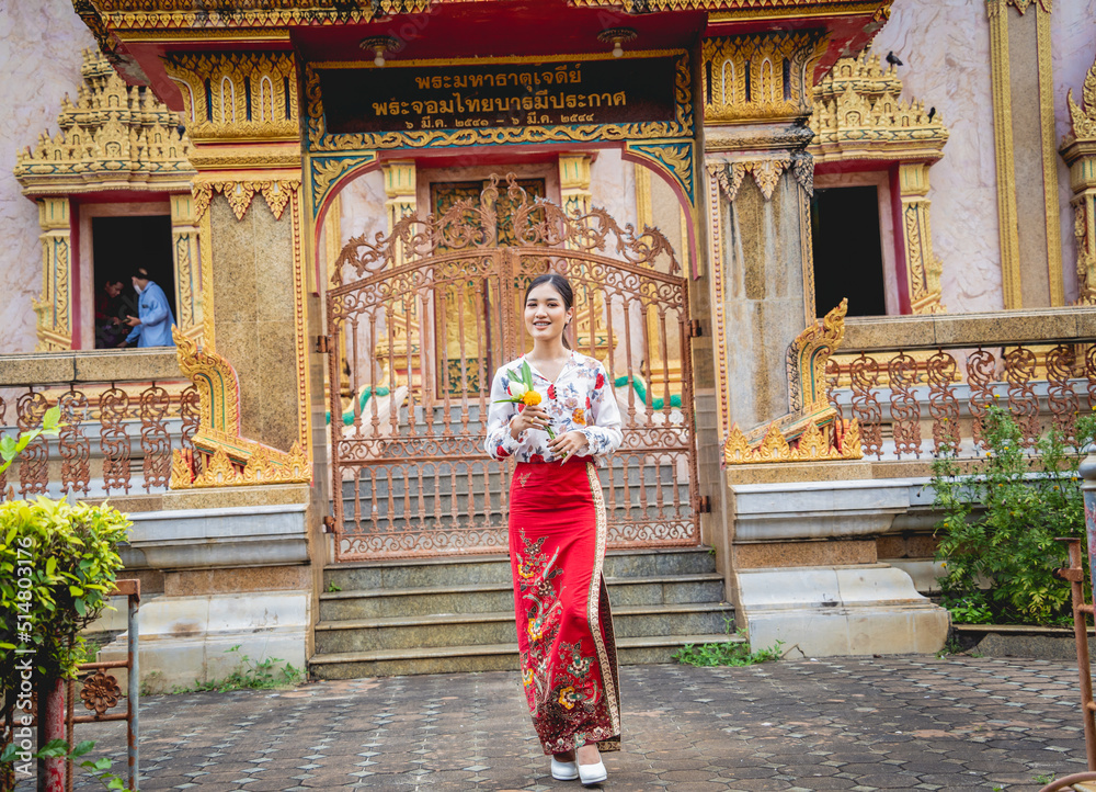 Fototapeta premium Beautiful Asian girl at big Buddhist temple dressed in traditional costume
