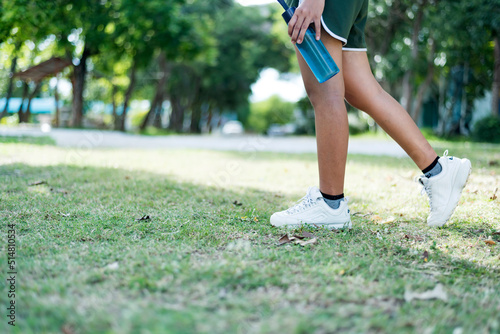 Woman walking in the park with bottle water in her hand health care concept.