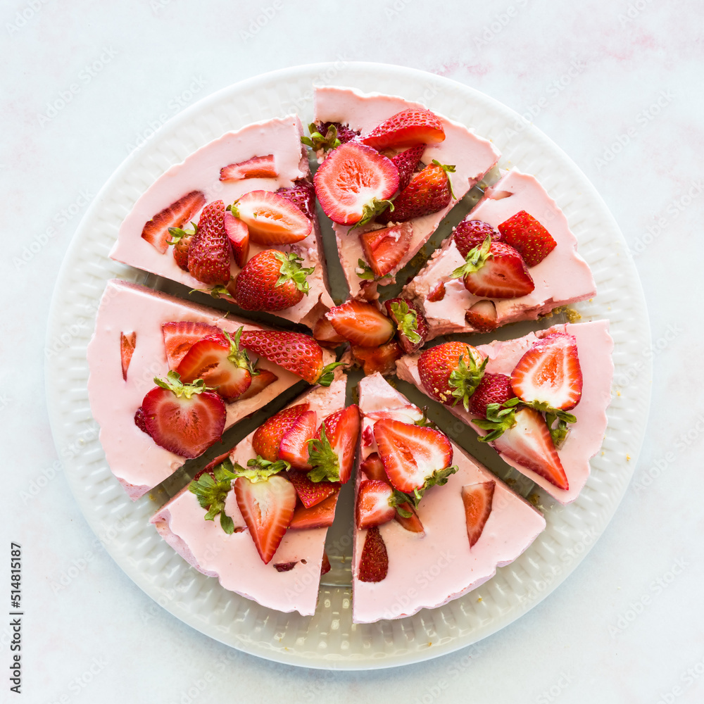 A fully sliced strawberry cheesecake taken from above. A fully sliced strawberry cheesecake taken from above.