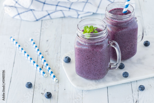 Jars of creamy blueberry smoothies ready for drinking.