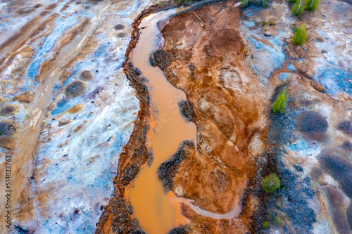 Dried rusty river bed over wasteland grey background, contamination texture, drone view directly above