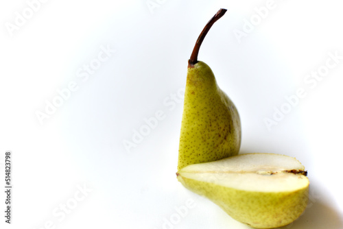 Sliced green pear in half on a white background