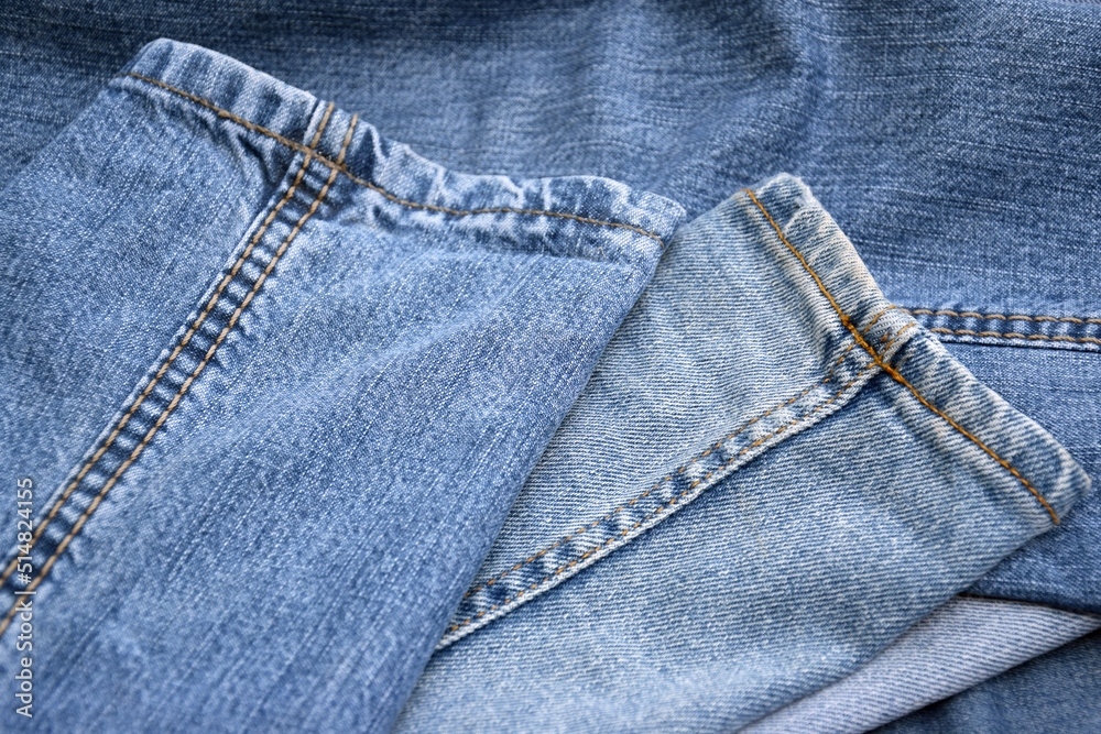 Fototapeta premium Lots of jeans pants in a stack. Denim background.