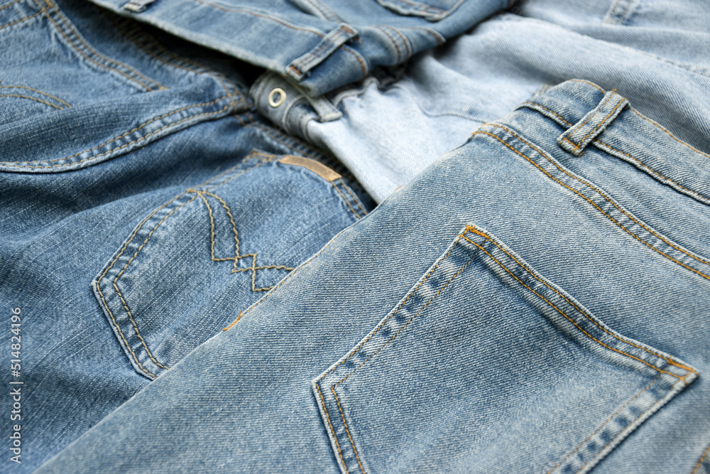 Fototapeta premium Lots of jeans pants in a stack. Denim background.