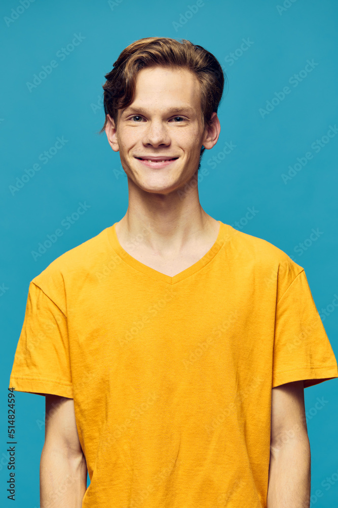 vertical portrait of a guy in a yellow T-shirt on a blue background vertical portrait of a guy in a yellow T-shirt on a blue background