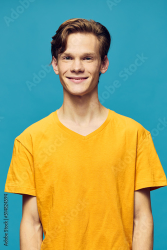 vertical portrait of a guy in a yellow T-shirt on a blue background
