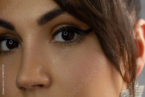 Beautiful macro of expressive brown eyes with fashionable pink smoky shadows, extremely long eyelashes. Cosmetology, eyebrow correction, eyelash extensions, makeup, cosmetics, eyesight, contact lenses