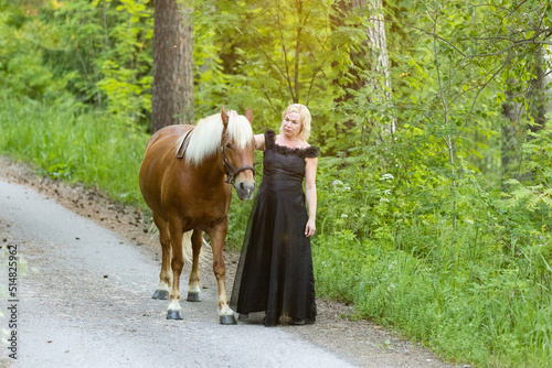 Woman posing with estonian horse in summer evening.