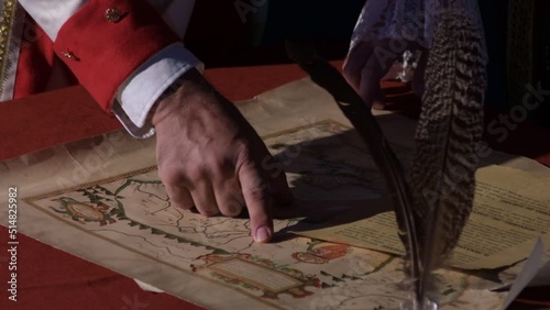 Hands of vintage characterized military generals pointing to an old map in a historical reenactment, Macharaviaya, Spain photo