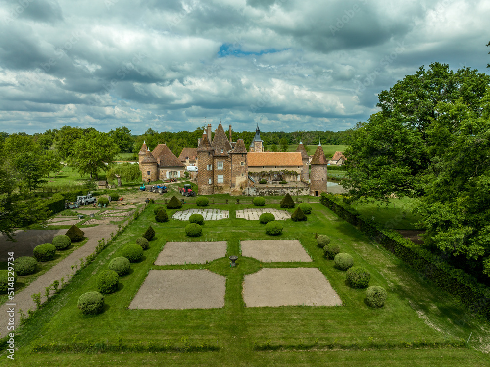 Aerial view of Chteau de la Cour-en-Chapeau in Allier France constructed with black diamond-shaped bricks on a background of red bricks, palace, gate tower, corner towers and moat Aerial view of Chteau de la Cour-en-Chapeau in Allier France constructed with black diamond-shaped bricks on a background of red bricks, palace, gate tower, corner towers and moat