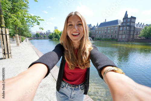 Selfie of young woman with the complex of buildings Binnenhof on Hofvijver in The Hague, Netherlands photo