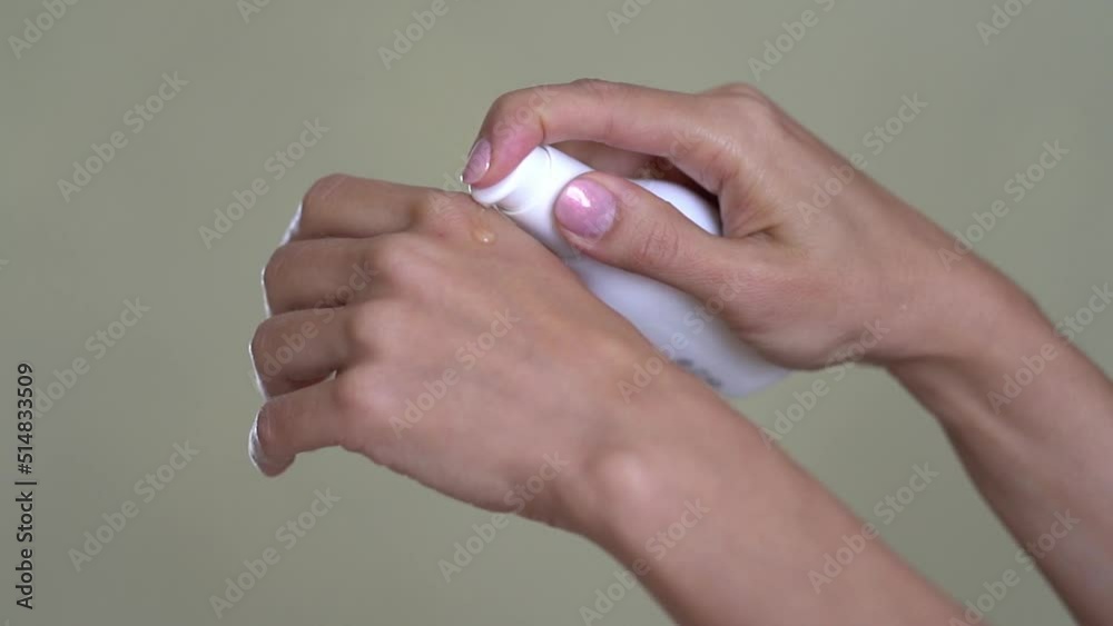 A woman applies moisturizing oil to her hand at home.The hands of a young girl with good skin, oil is poured on one hand. The concept of hand care with cosmetic oil. High quality FullHD footage A woman applies moisturizing oil to her hand at home.The hands of a young girl with good skin, oil is poured on one hand. The concept of hand care with cosmetic oil. High quality FullHD footage