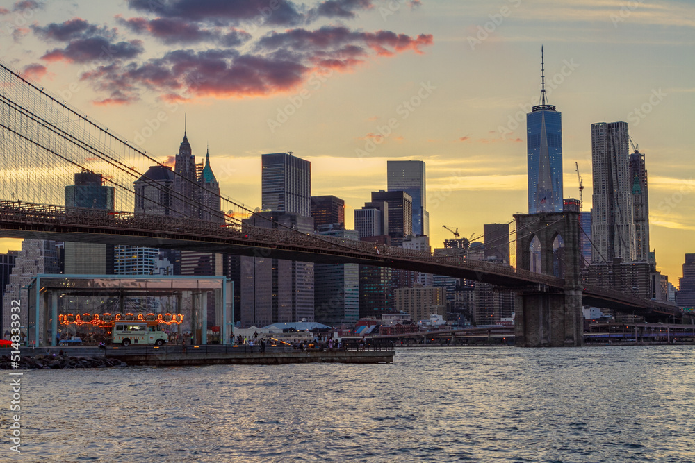 View of Manhattan at dusk with the Brooklyn Bridge in the foreground