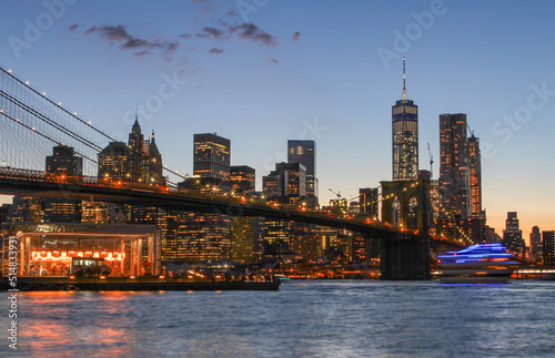 View of Manhattan at dusk with the Brooklyn Bridge in the foreground