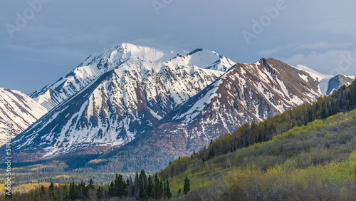 Winter landscape in northern Canada with snow capped mountains surrounding wilderness setting in Carcross, Yukon Territory during late winter early spring April. © Scalia Media