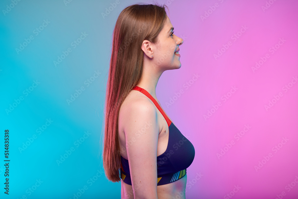 Profile portrait of sporty woman in fitness sportswear. Female fitness portrait isolated on neon multicolor background. Profile portrait of sporty woman in fitness sportswear. Female fitness portrait isolated on neon multicolor background.