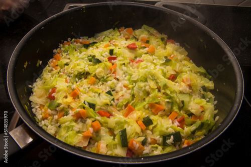 Detail of rice and vegetables cooking in a large pot. Healthy meal.