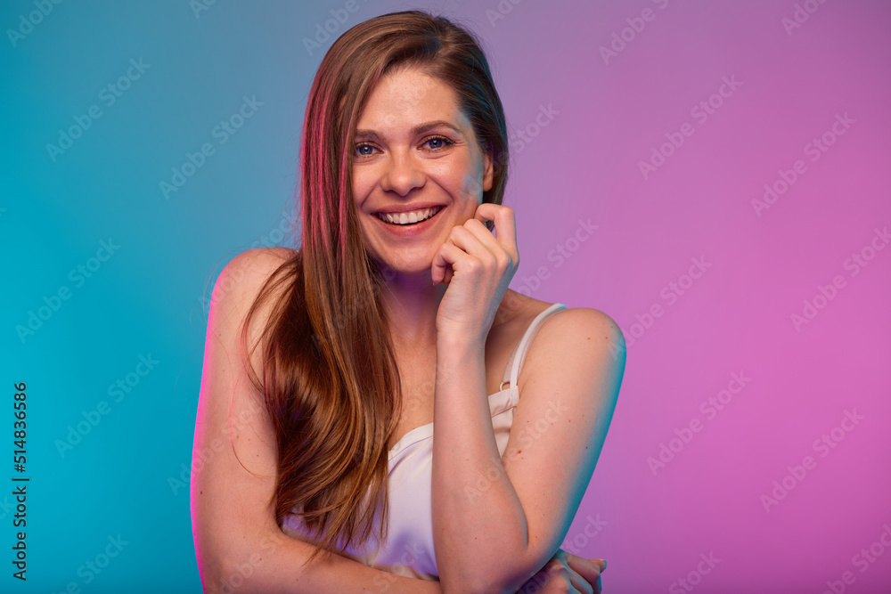 Fototapeta premium Smiling woman face portrait with neon lights colors effect. Girl isolated on neon background.