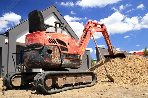 A mini excavator prepared to spread the aggregate on the construction site. Minikoparka przygotowana do rozrzucania kruszywa na placu budowy.