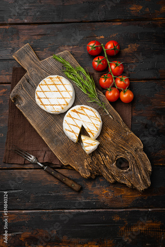 Grilled camembert or brie cheese on old dark  wooden table background, top view flat lay, with copy space for text