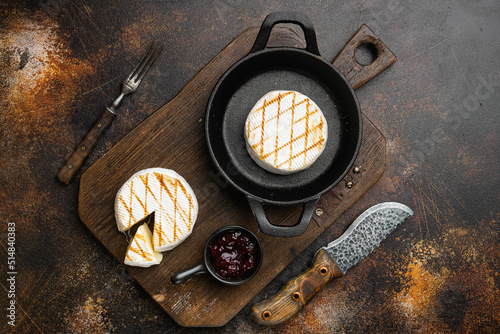 Grilled goat cheese on old dark rustic table background, top view flat lay
