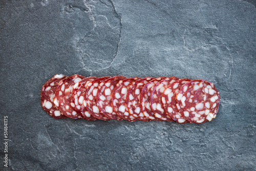 Smoked sausage salami slice isolated on dark background with clipping path and full depth of field.