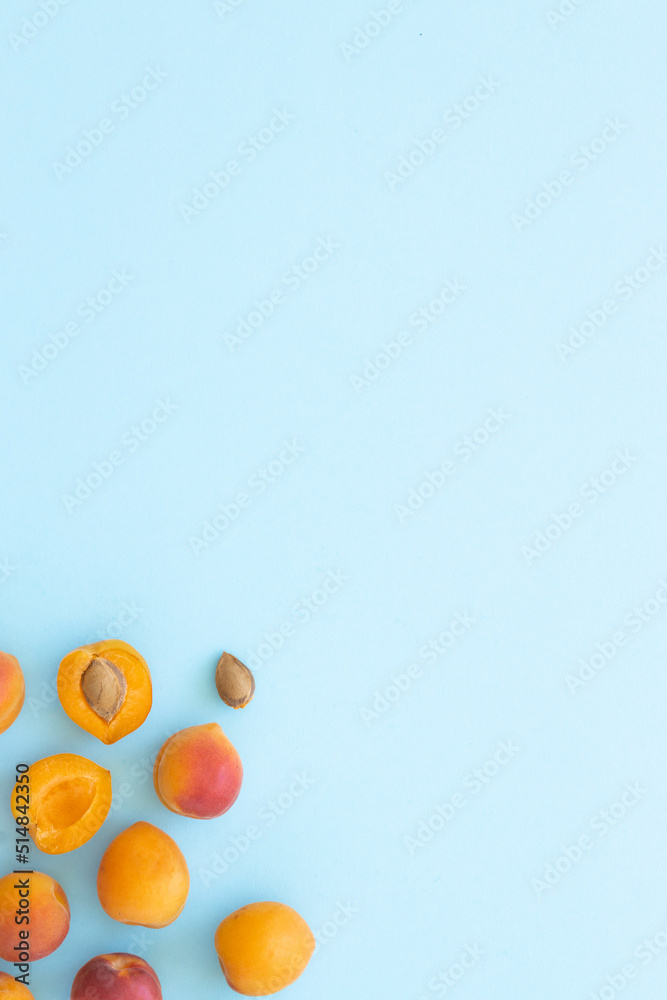 Delicious ripe sweet apricots on blue background, flat lay. Space for text