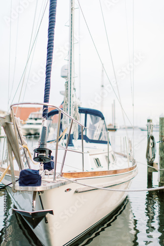 A white yacht sailboat is docked at a pier marina in Florida. 
