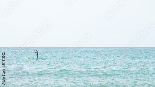 Silhouette of a man kayaking in the distance on the waters of the Mediterranean Sea