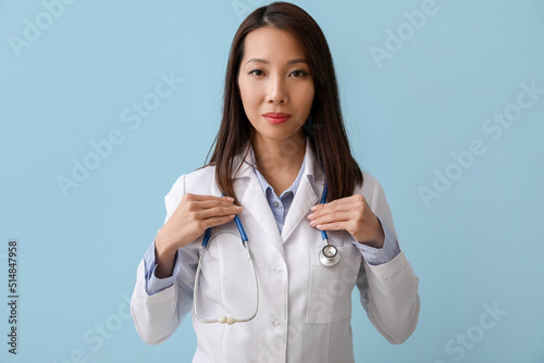 Female Asian doctor on blue...